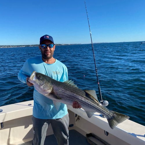 a man in a blue shirt holding a fish